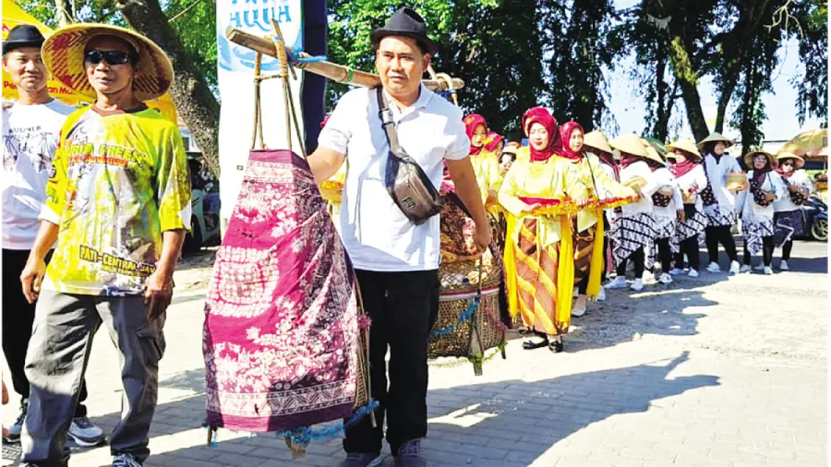 KULINER KHAS: Peserta kirab memikul keranjang bambu wadah lentog Tanjung yang diarak mengikuti rute kirab di Desa Tanjungkarang, Jati, Kudus, kemarin. (ANDIKA TRISNA SAPUTRA/RADAR KUDUS)
