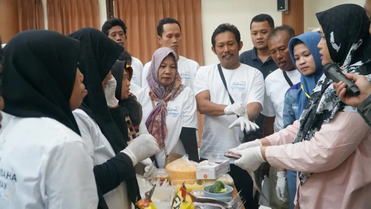 Narasumber pelatihan, Kholifah dari Ikan Kembar, memberikan praktik langsung pengolahan bandeng kepada peserta Pelatihan Pengembangan Usaha Olahan Perikanan Berbasis Potensi Lokal Program Bandeng Kalingga. 