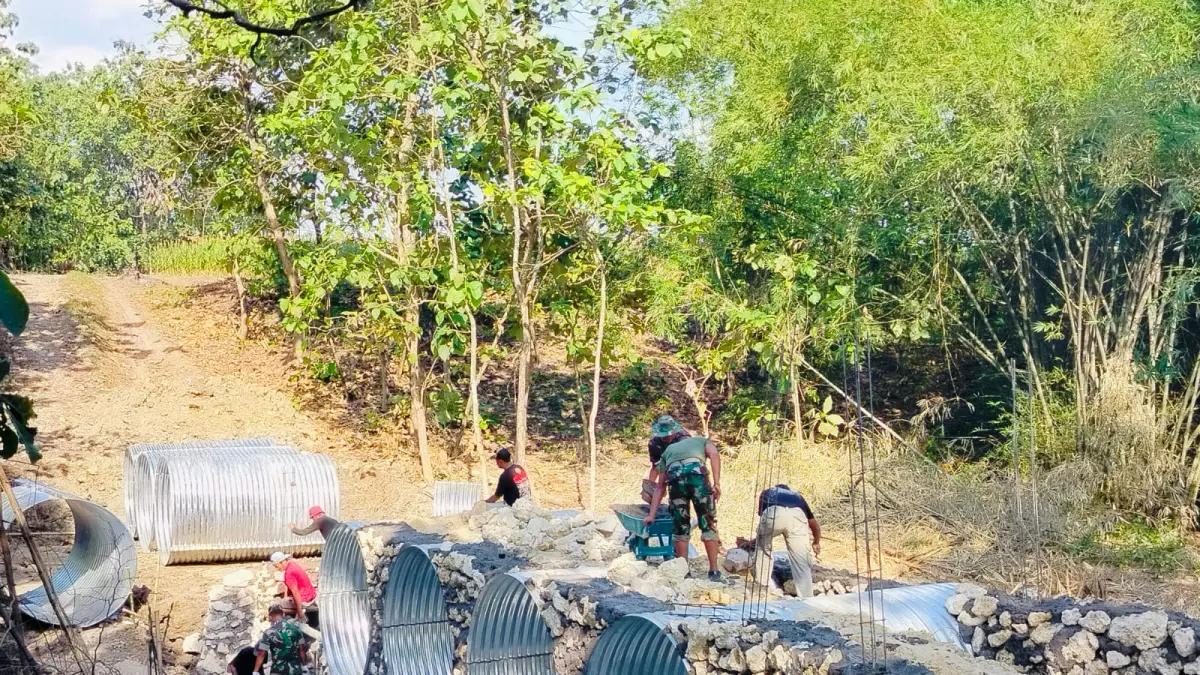 GOTONG ROYONG: Babinsa Koramil 17/Kradenan saat melakukan pembangunan jembatan armco di Desa Pakis Kecamatan Kradenan.