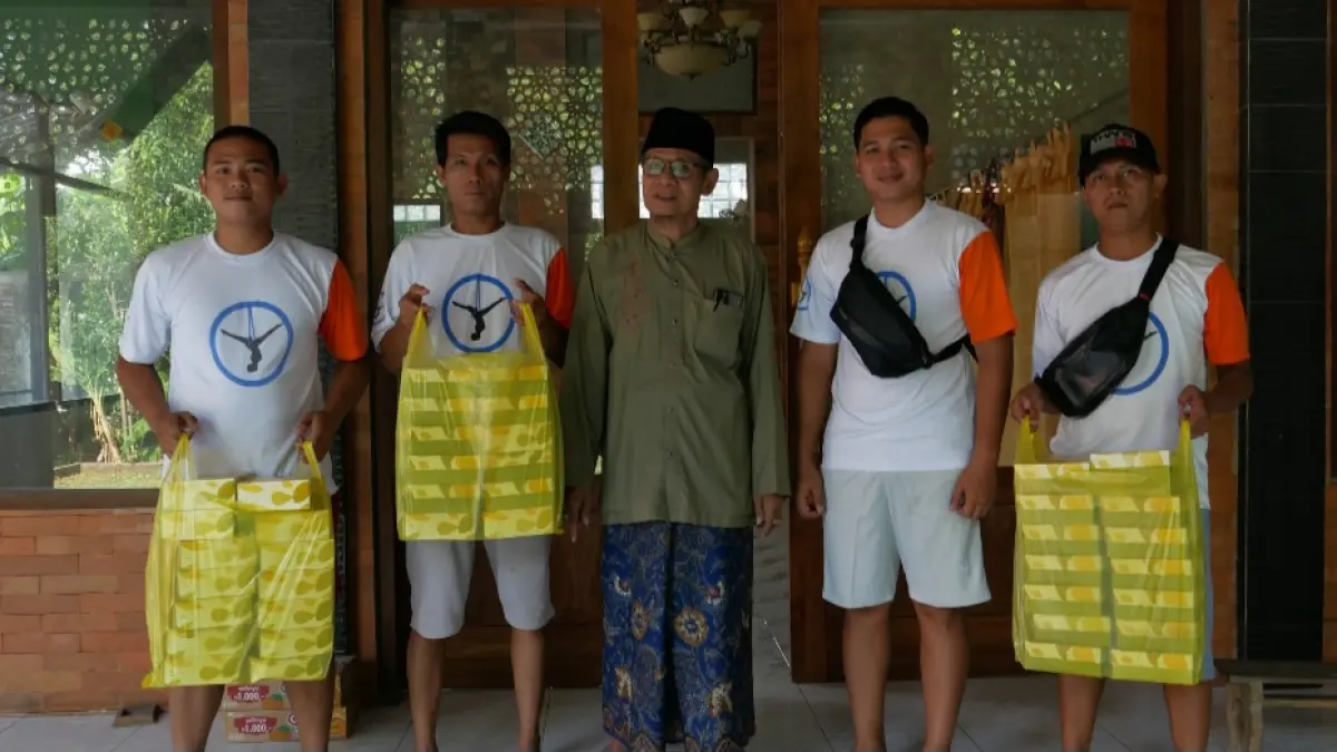 BERMANFAAT: Kiai Khasbullah menerima sedekah snack dari Komang Aryes untuk acara di musala pada Kamis (18/6) malam Jumat. Musala tersebut juga merupakan bangunan yang dibangunkan oleh pemilik Wisata Udara Yoga tersebut.&nbsp;(FIKRI THOHARUDIN/RADAR KUDUS)