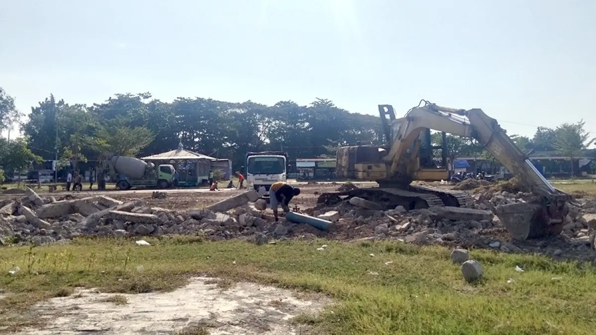 DIBANGUN: Petugas membersihkan sisa-sisa bangunan di Alun-alun Kembangjoyo kemarin. (ANDRE FAIDHIL FALAH/RADAR KUDUS)