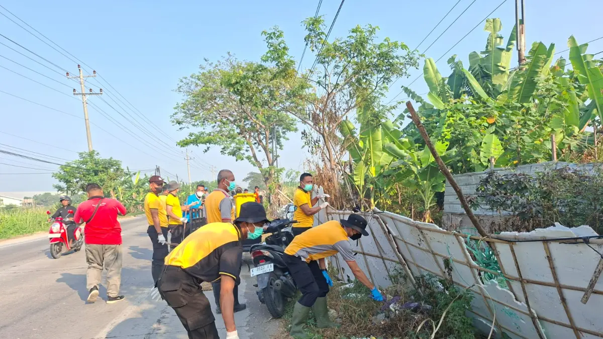 BERSIHKAN SAMPAH –  Anggota Polsek Gubug bersama DLH dan warga masyarakat sekitar membersihkan sampah di pinggir jalan yang menumpuk dan sempah viral. 