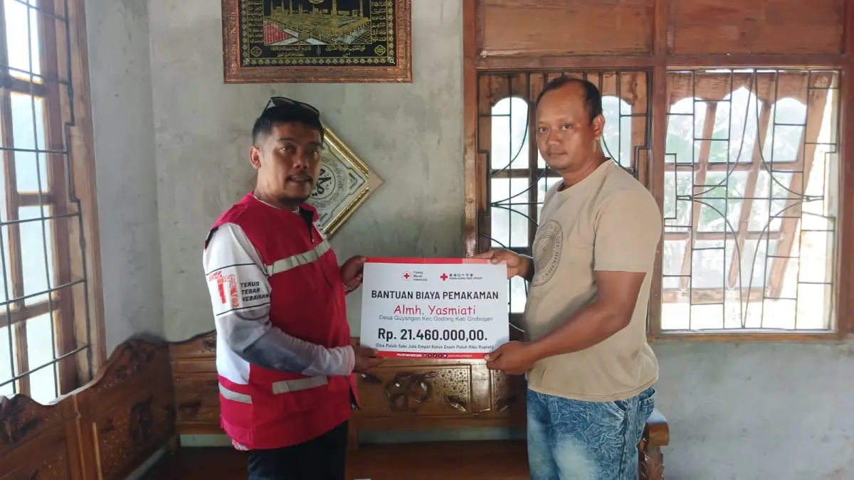 BANTUAN: Kepala Seksi Pelayanan PMI Kabupaten Grobogan, Gesit Kristyawan saat menyerahkan bantuan ke keluarga korban.