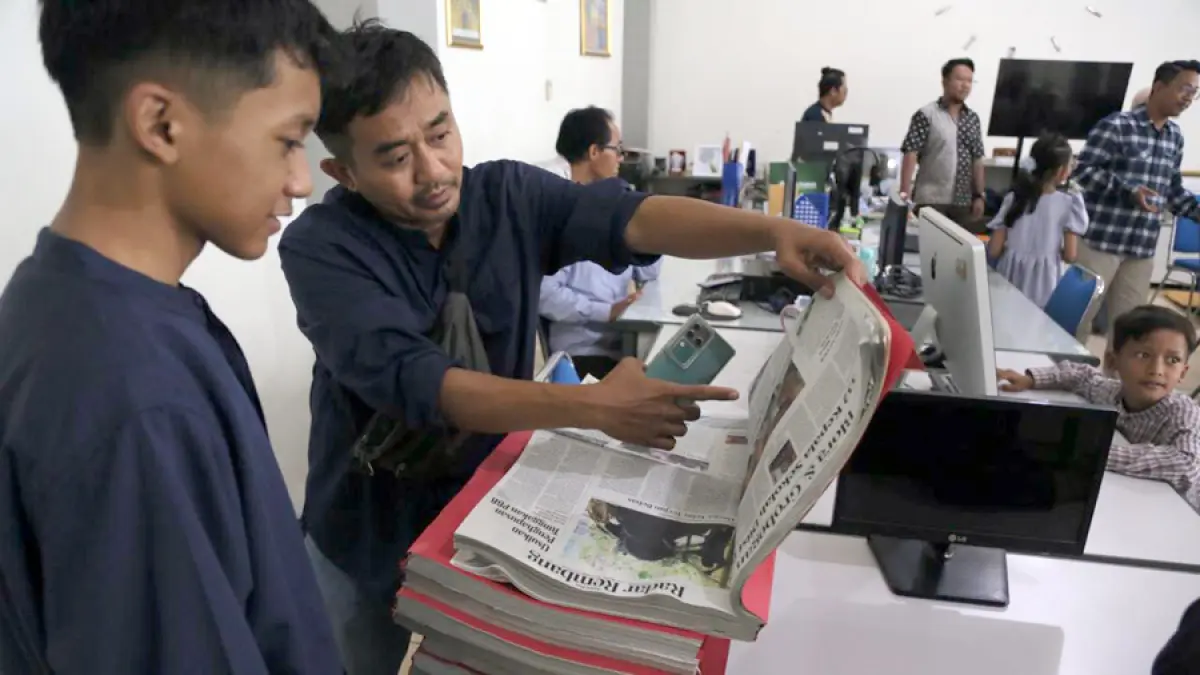 KENALKAN PRODUK: Kepala Radar Kudus Biro Grobogan (dua dari kanan) menerangkan halaman koran Jawa Pos Radar Kudus kepada anaknya saat roo tour di ruang redaksi. (GALIH ERLAMBANG W/RADAR KUDUS)