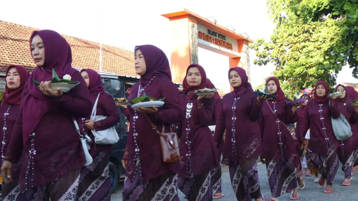 BERPARTISIPASI: Ibu-ibu tak mau ketinggalan, ambil peran dalam prosesi kirab.