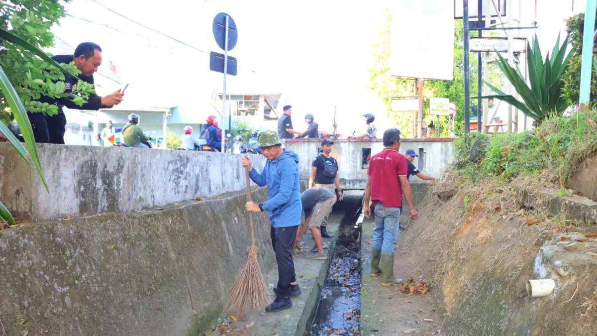 BERSIHKAN: Bupati Kudus, Sam’ani Intakoris turun langsung membantu membersihkan sampah di aliran sungai Jalan R. Agil Kusumadya, Jumat (26/6). (DINAS KOMINFO KUDUS UNTUK RADAR KUDUS)