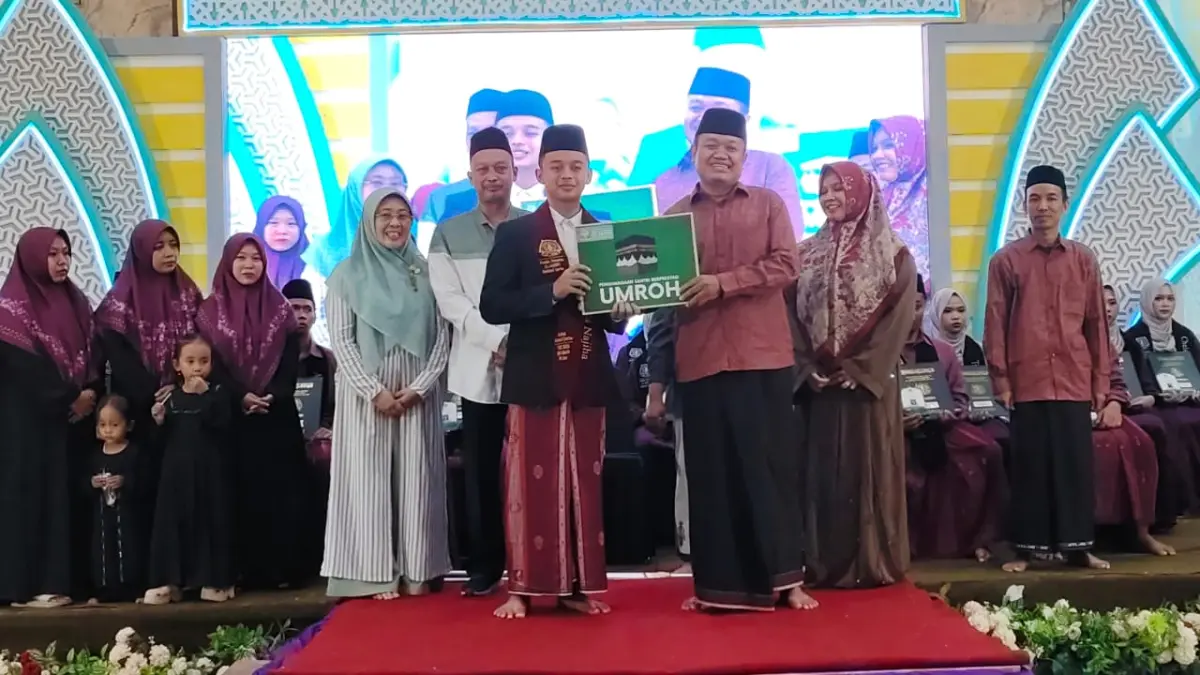 SERAHKAN HADIAH – Pengasuh Ponpes Al Aqsho Moch Farhan Ali Imron menyerahkan hadiah Umroh kepada Albir Fayruza Najiha yang berhasil menuntaskan hafalan 30 juz dalam waktu tiga tahun. 