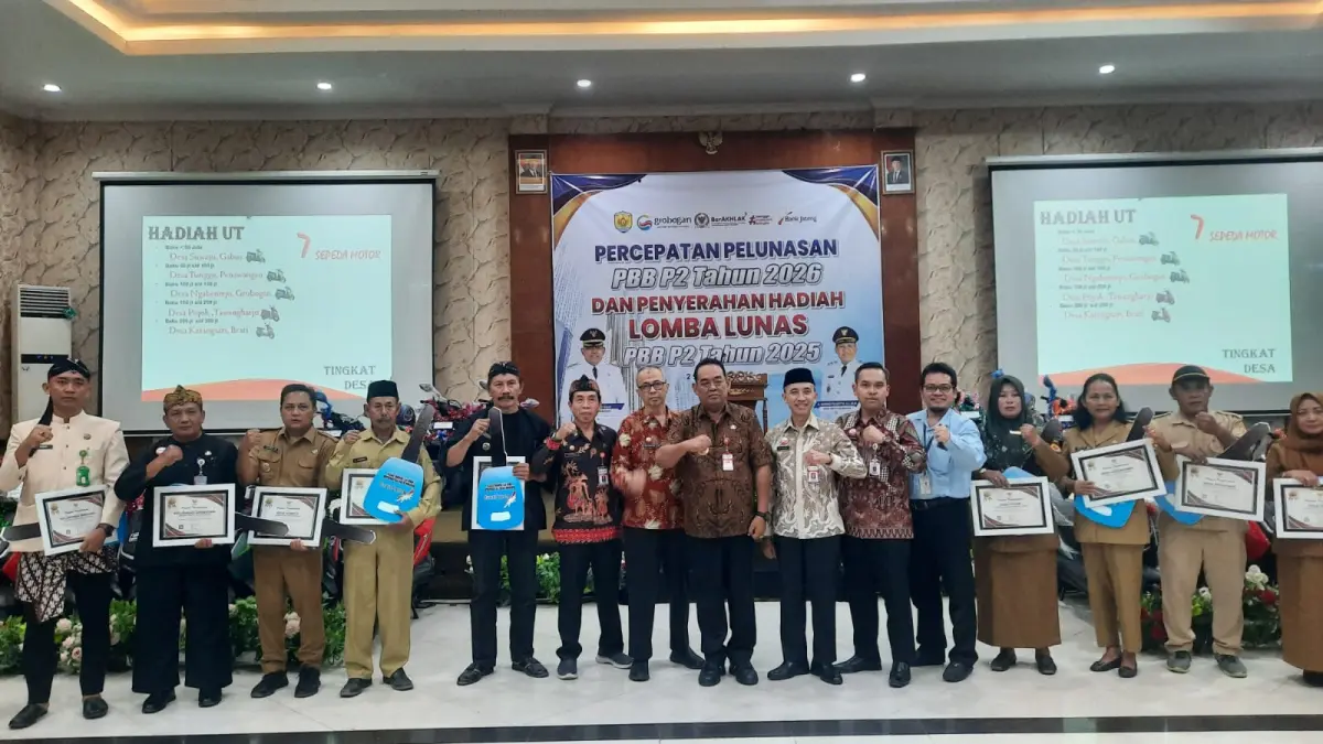 DISERAHKAN: Bupati Grobogan Setyo Hadi saat menerima hadiah di Percepatan Pelunasan PBB-P2 Tahun 2025.