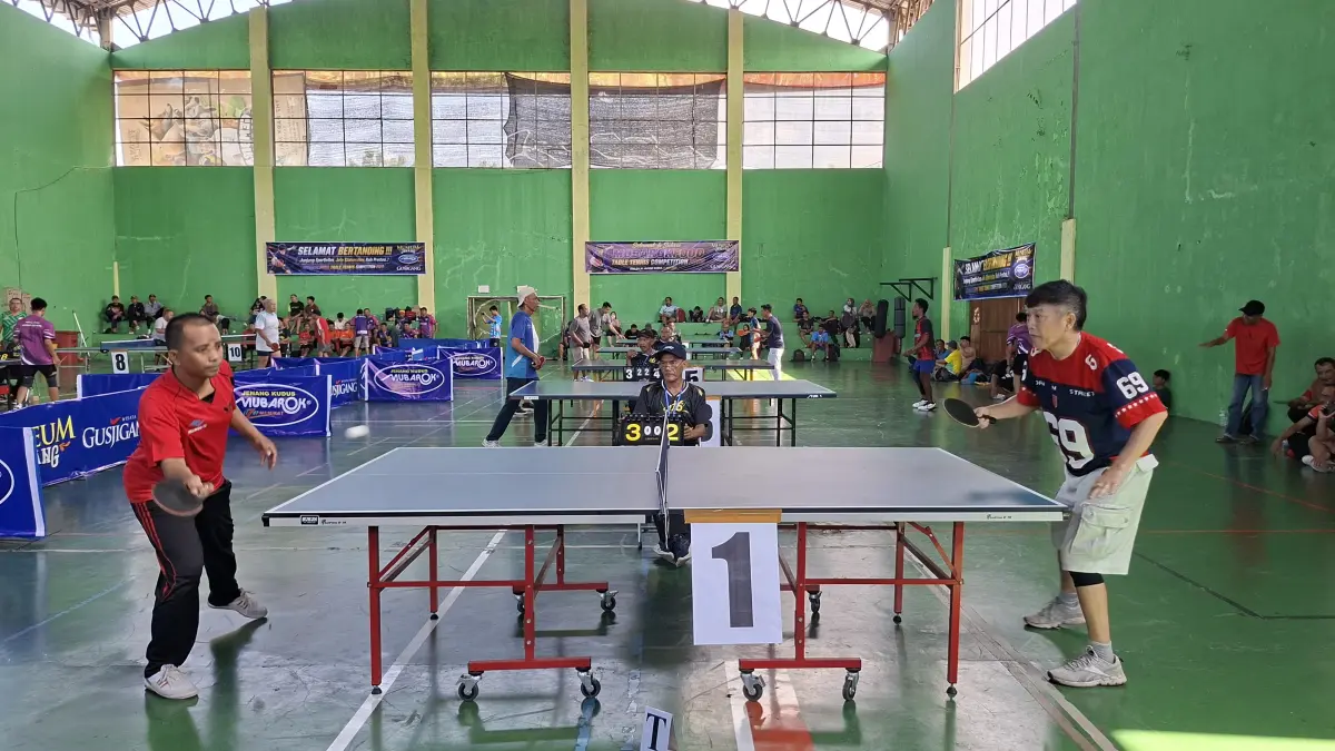 SENGIT: Peserta kompetisi tenis meja beradu serangan di GOR Lapangan Tenis Indoor Balai Jagong, Kudus, Minggu (5/7). (ANDIKA TRISNA SAPUTRA/RADAR KUDUS)