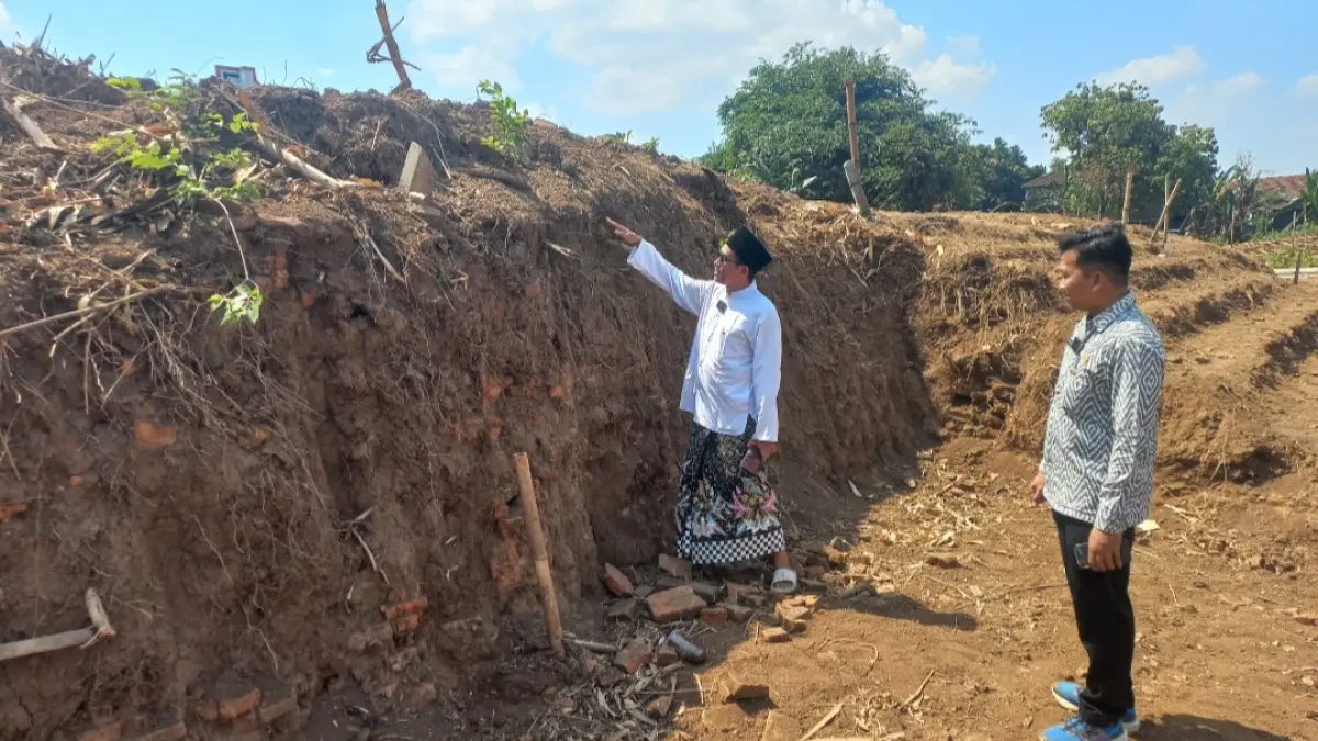 MENJULANG: Pengasuh Ponpes Nailun Najah Assalafy Gus Mad serta Petinggi Desa Kriyan M. Khanafi mengajak menilik kondisi struktur bata kuno di Desa Kriyan yang tampak menghampar luas, serta masih terkubur, pada Selasa (7/7).&nbsp;(FIKRI THOHARUDIN/RADAR KUDUS)&nbsp;
