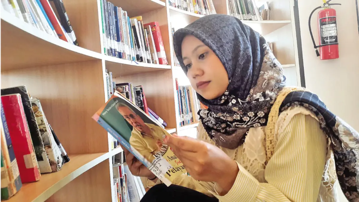 ASIK MEMBACA: Pengunjung memilihmilih buku di rak sembari membaca di Gedung C Perpusda Kudus. (INDAH SUSANTI/RADAR KUDUS)