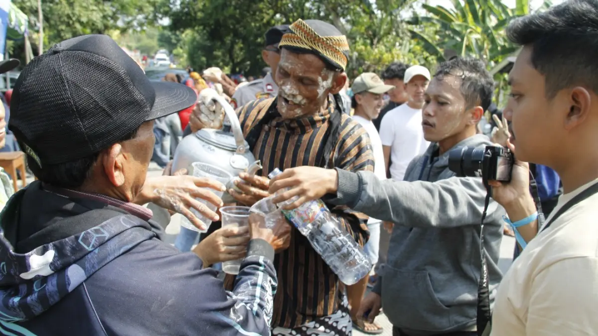 ANTUSIAS: Sejumlah warga meminta wedang tape dan bedak dalam prosesi inti Asrah Batin. (FIKRI THOHARUDIN/RADAR KUDUS)