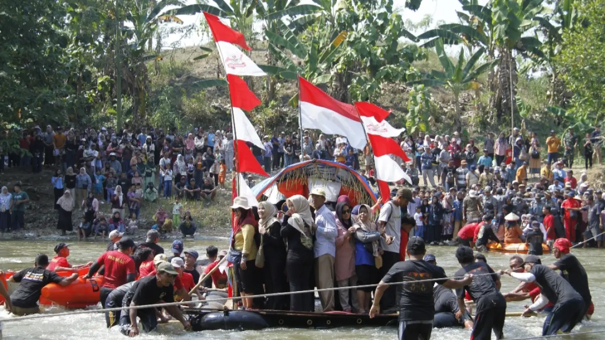 KHIDMAT: Warga Desa Karanglangu tengah menyeberang melewati Sungai Tuntang menuju Desa Ngombak Kecamatan Kedungjati dalam Tradisi Asrah Batin pada Minggu Kliwon (12/7). (FIKRI THOHARUDIN/RADAR KUDUS)