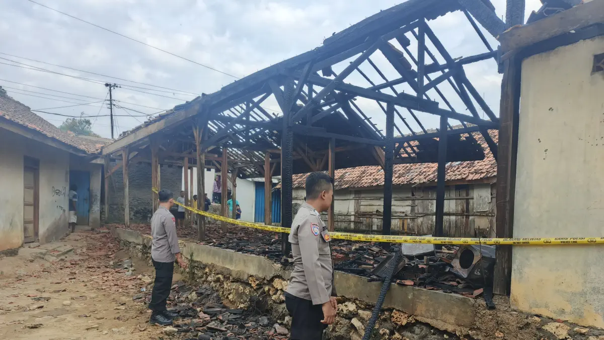 POLICE LINE – Anggota Polsek Wirosari memasang garis police line di lokasi Pasar Tegalrejo terbakar karena korsleting listrik. 