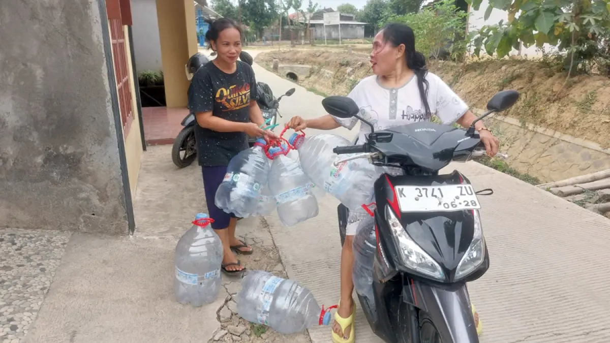 SULIT AIR: Warga Gabus mengambil air menggunakna galon di salah satu kediaman warga setempat kemarin. (ANDRE FAIDHIL FALAH/RADAR KUDUS)