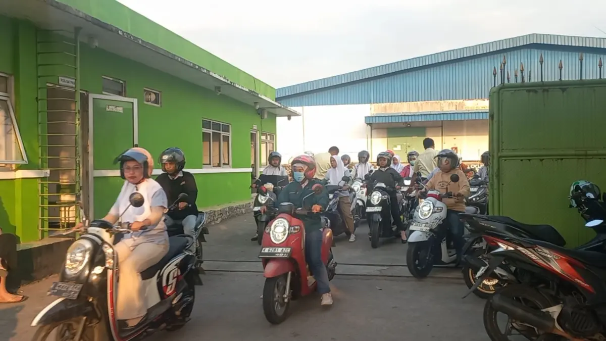 RAMPUNG: Para pekerja keluar dari gedung pabrik PT Samwon, pulang ke rumah, usai bekerja seharian pada Selasa (21/7). (FIKRI THOHARUDIN/RADAR KUDUS)