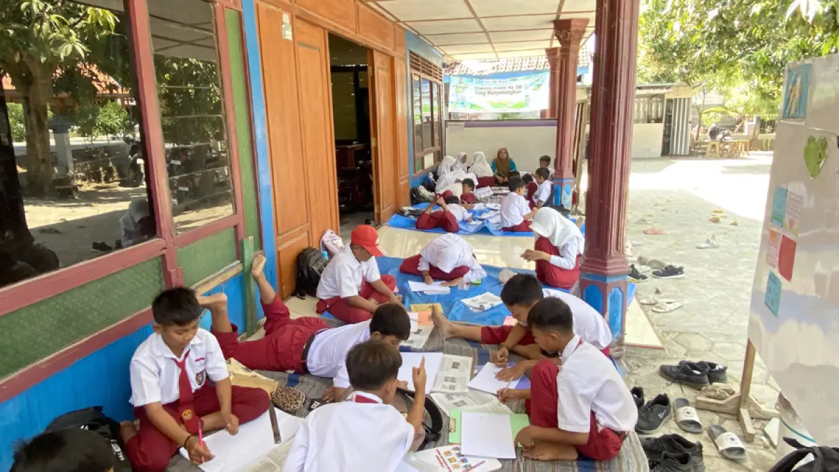 LESEHAN: Siswa kelas III dan IV SDN Jetak belajar di salah satu rumah warga akibat seluruh&nbsp;ruang kelas dibongkar dengan bantuan APBN 2026. (ARIF FAKHRIAN KHALIM/RADAR KUDUS)