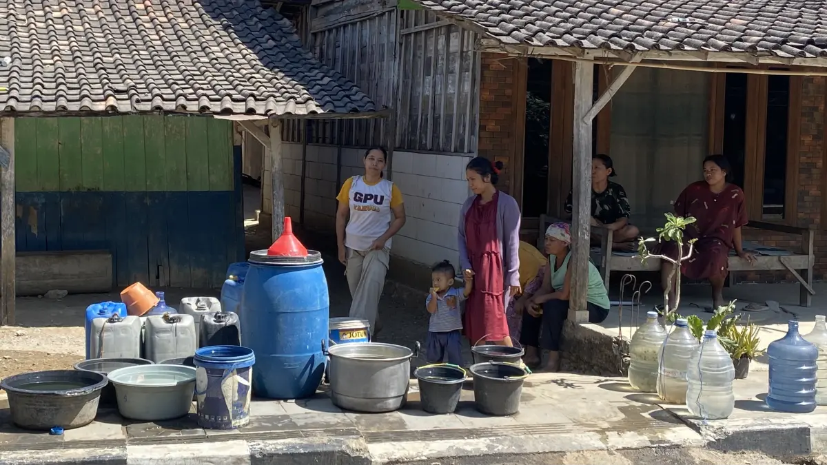 ANTRE: Warga Desa Kedungringin Kecamatan Tunjungan menunggu giliran droping air bersih didepan rumah masing-masing. 
