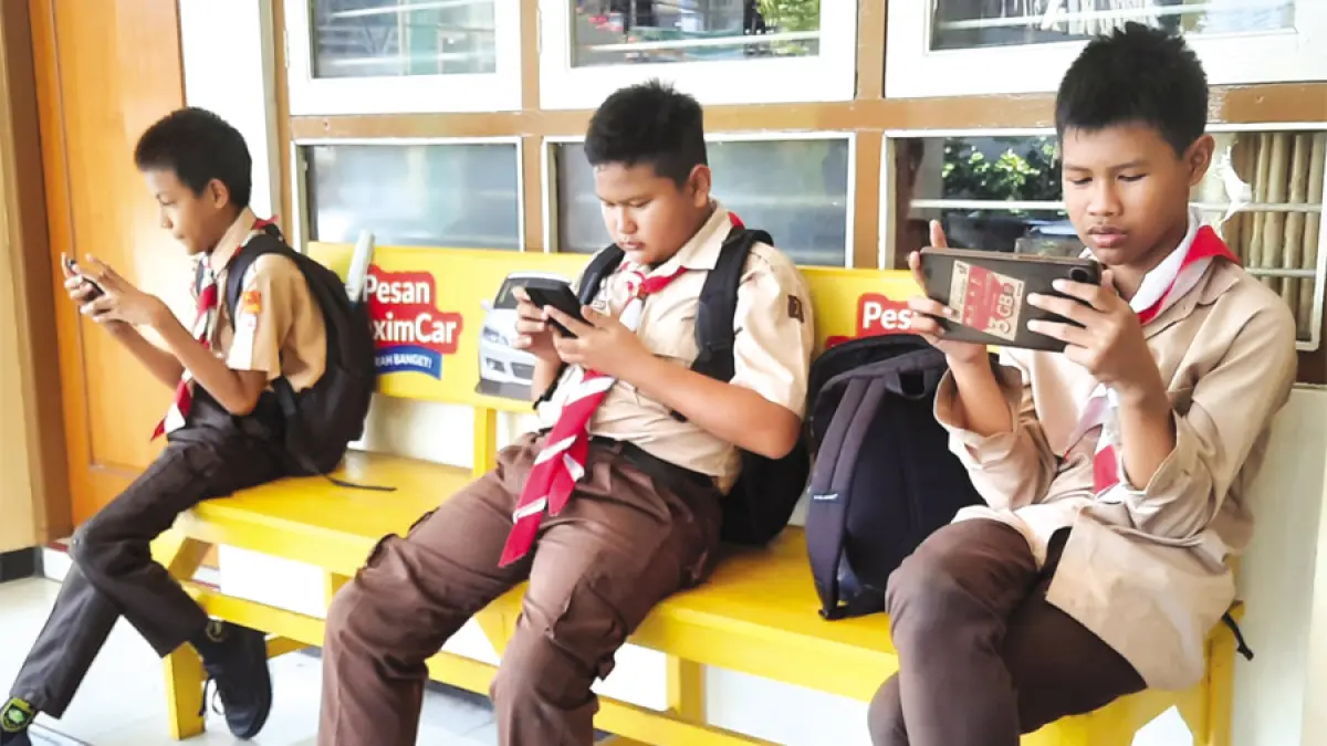 TERDIAM: Murid yang duduk berjejer sibuk dengan ponsel tanpa ada obrolan. (INDAH SUSANTI/RADAR KUDUS)