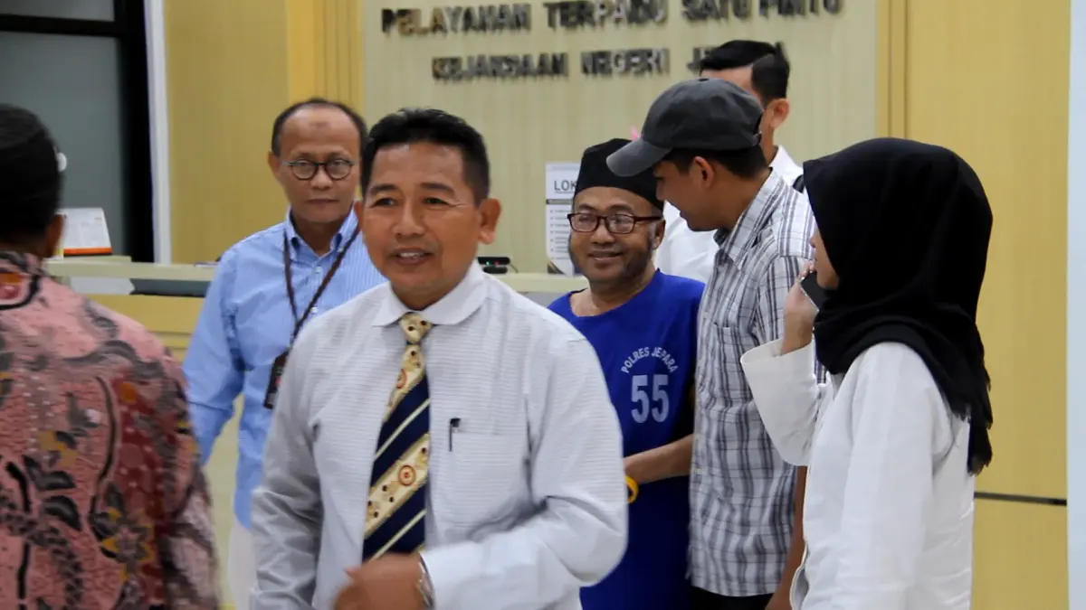 BUGAR: Terduga pelaku pencabulan terhadap santriwati Ponpes Al Anwar Mantingan Abi Jamroh (baju tahanan biru) didampingi keluarga dan kuasa hukum saat menjalani pelimpahan tersangka dan barang bukti, pada Senin (27/7). (FIKRI THOHARUDIN/RADAR KUDUS) 