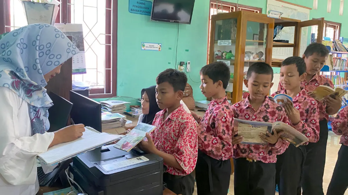 MENYERAP ILMU: Anak-anak SDN Balong, Kecamatan Jepon membaca dan meminjam buku di Perpustakaan Desa Balong saat jam istirahatat sekolah. (ARIF FAKHRIAN KHALIM/RADAR KUDUS)