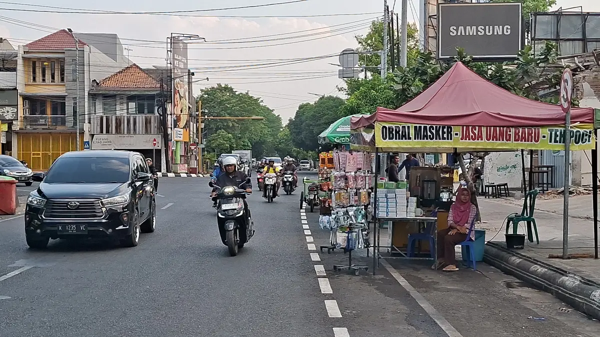 TERHALANG: Sejumlah PKL di kawasan Alun-alun Simpang Tujuh Kudus menghalangi jalur sepeda yang baru jadi, Rabu (29/7). (ANDIKA TRISNA SAPUTRA/RADAR KUDUS)