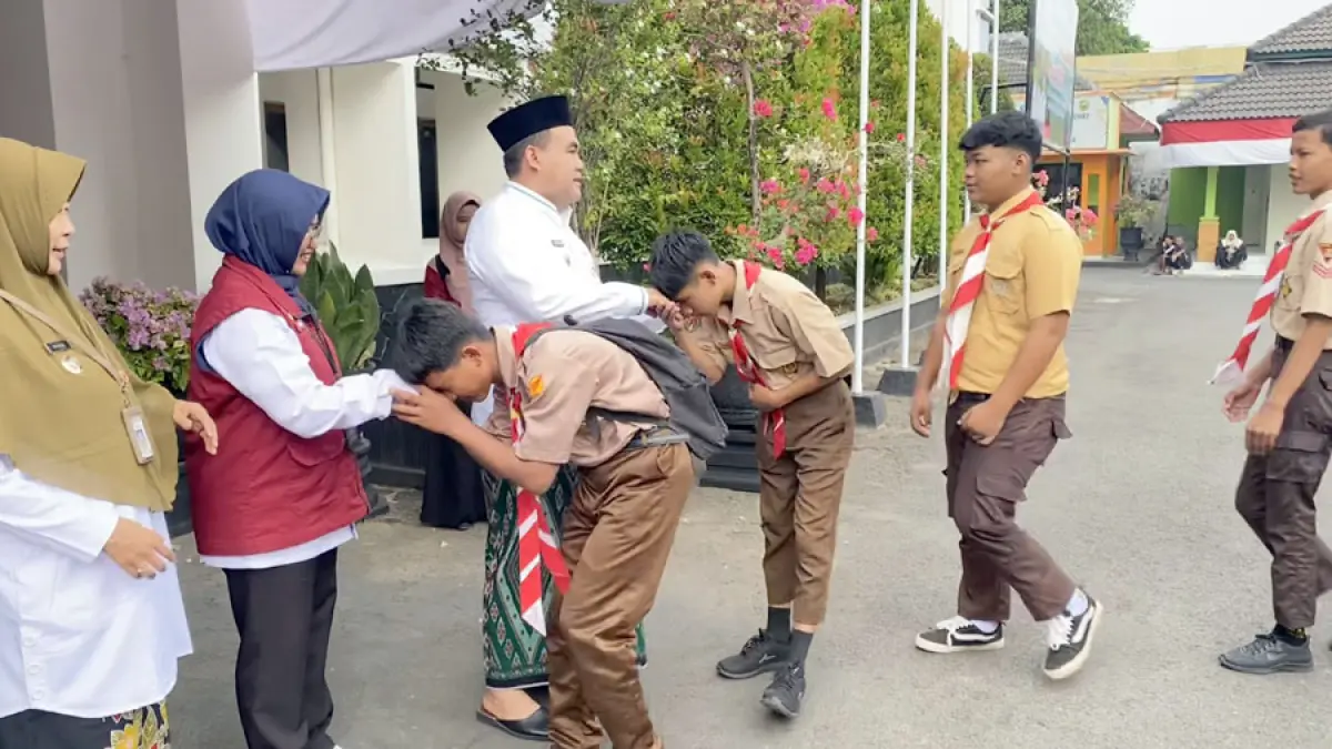 PAMITAN: Siswa SRMA 18 Blora mencium tangan Bupati Blora Arief Rohman untuk berpamitan menempuh pendidikan di SRT Rembang. (ARIF FAKHRIAN KHALIM/RADAR KUDUS)