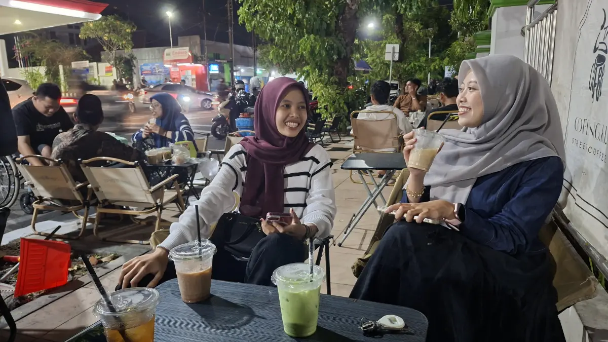SANTAI: Seorang pemudi menikmati ngopi bersama temannya untuk melepas penat di street coffee Jalan Jenderal Soedirman Kudus, kemarin. (ANDIKA TRISNA SAPUTRA/RADAR KUDUS)
