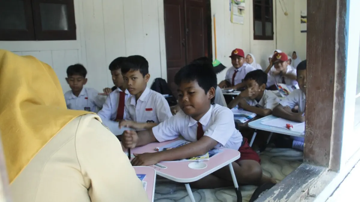 PANTANG MENYERAH: Guru beserta peserta didik di SDN 1 Tedunan Kecamatan Kedung, tetap melakukan pembelajaran, meski atap ruang kelas ambrol. Pembelajaran dilakukan di rumah warga di sekitar sekolah. (FIKRI THOHARUDIN/RADAR KUDUS)
