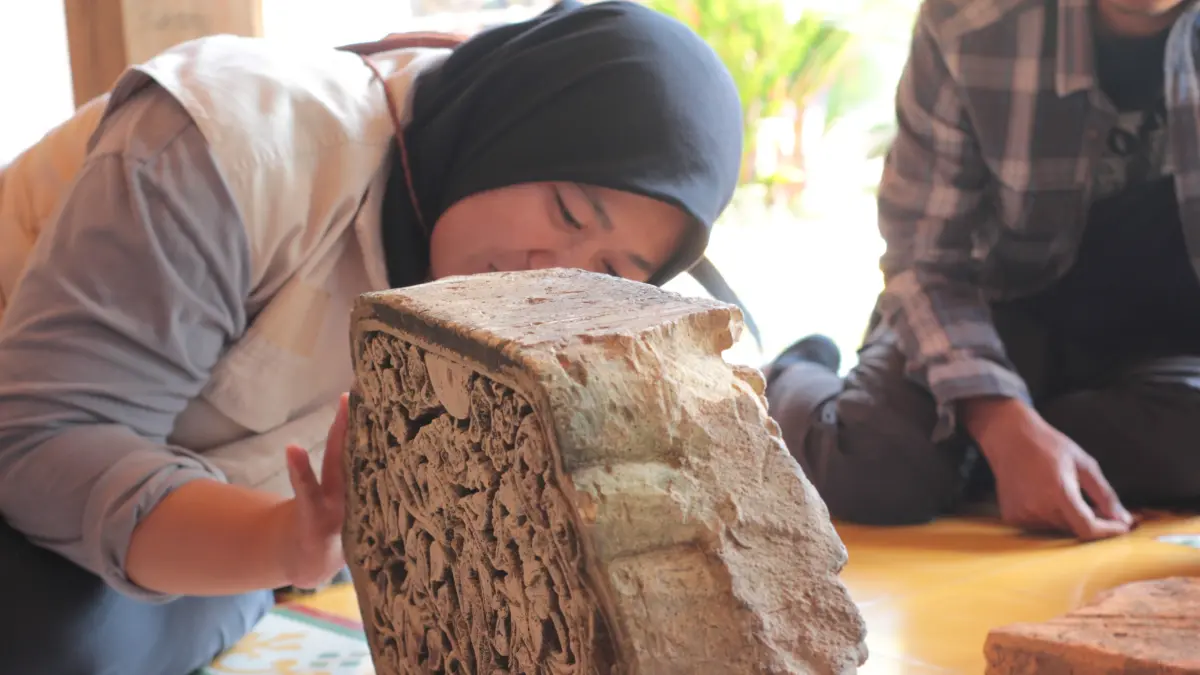 MENDETAIL: Dosen Teknik Geologi Universitas Diponegoro, Anis Kurniasih tengah menilik relief atau ornamen dua sisi, yang bermotif Kalabhairawa serta Sulur-suluran pada Selasa (5/8). (HISYAM UNTUK RADAR KUDUS)