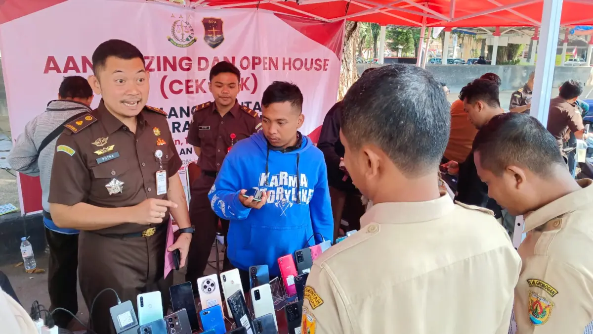 LIHAT LELANG – Warga masyarakat melihat barang bukti yang di lelang di depan kantor Kejari setempat, Senin (10/8)