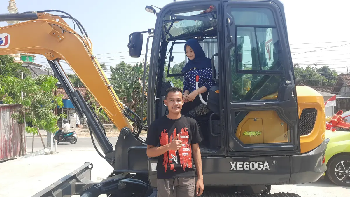 ROMANTIS: Rico dan Laella saat berdiri di samping ekskavator yang dijadikan mahar pernikahan mereka. (INTAN MAYLANI SABRINA/RADAR KUDUS)
