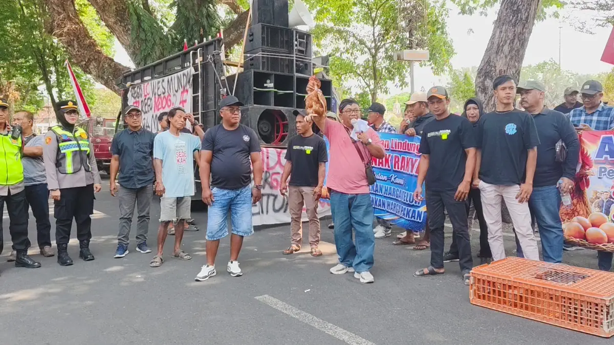 BAGI AYAM – Korlap Aksi Aliansi Peternak Ayam Peternak Grobogan Sugiyanto membawa ayam sebagai bentuk aksi atas turunya harga telur ayam dan mahalnya harga pakan di depan Pendopo Kabupaten, Senin (10/8). 