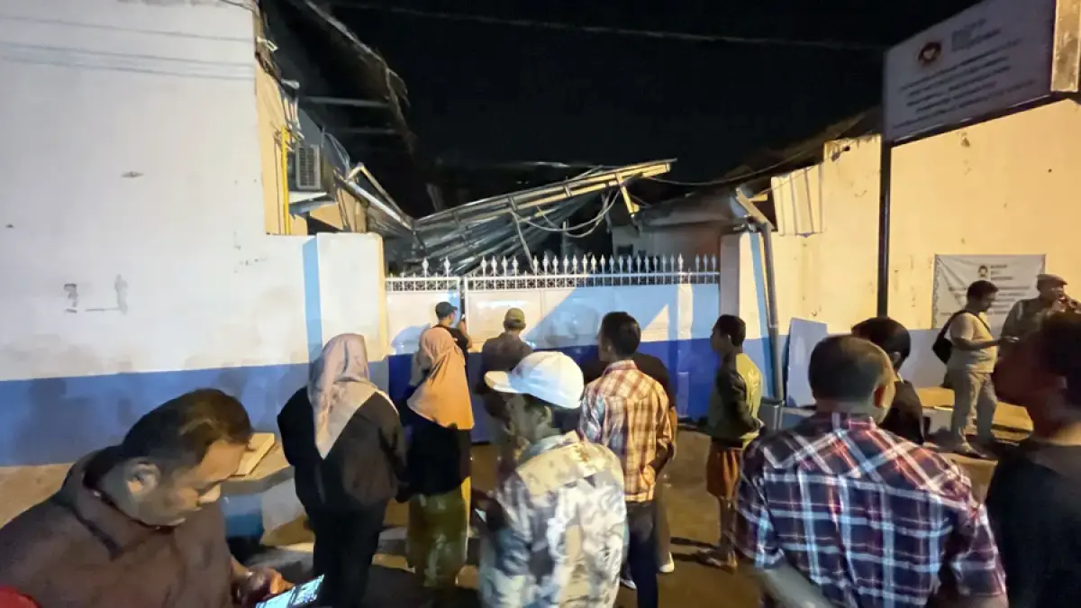 AMBRUK: Warga melihat kondisi SPPG Medali 1, Desa Medali, Kecamatan Puri, Kabupaten Mojokerto yang meledak dan terbakar, Kamis (13/8) malam.
