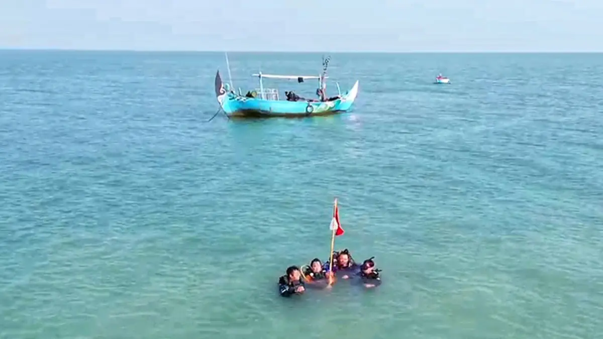 SELESAIKAN MISI: Dua atlet dan pengurus POSSI Rembang bersiap mengibarkan bendera di bawah laut perairan Pulau Gede, Rembang, Sabtu lalu (15/8). (POSSI RBG UNTUK RADAR KUDUS)