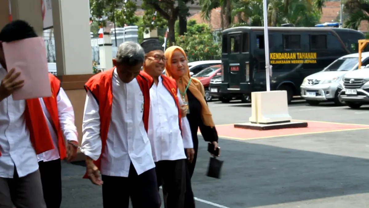 PERCAYA DIRI: Abi Jamroh (kanan berpeci) terdakwa kasus dugaan kekerasan seksual terhadap santriwatinya di Ponpes Al Anwar Mantingan Kecamatan Tahunan digandeng oleh sang istri usai menjalani sidang di PN Jepara pada Rabu (19/8). (FIKRI THOHARUDIN/RADAR KUDUS)