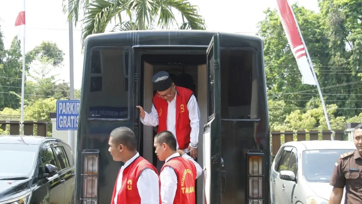 SUMRINGAH: Abi Jamroh (atas berpeci) terdakwa kasus dugaan kekerasan seksual terhadap santriwati Ponpes Al Anwar Mantingan Kecamatan Tahunan tersenyum saat turun dari mobil tahanan Kejari Jepara, untuk menjalani sidang di PN Jepara pada Rabu (19/8). (FIKRI THOHARUDIN/RADAR KUDUS)