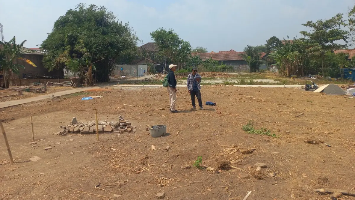 TELITI: Peneliti BRIN Ida Bagus Putu Prajna Yogi (kiri) mendampingi perwakilan dari BPK melakukan pemetaan kawasan dengan foto udara lewat drone di Kriyan, Kalinyamatan, pada Selasa (4/8). (FIKRI THOHARUDIN/RADAR KUDUS)