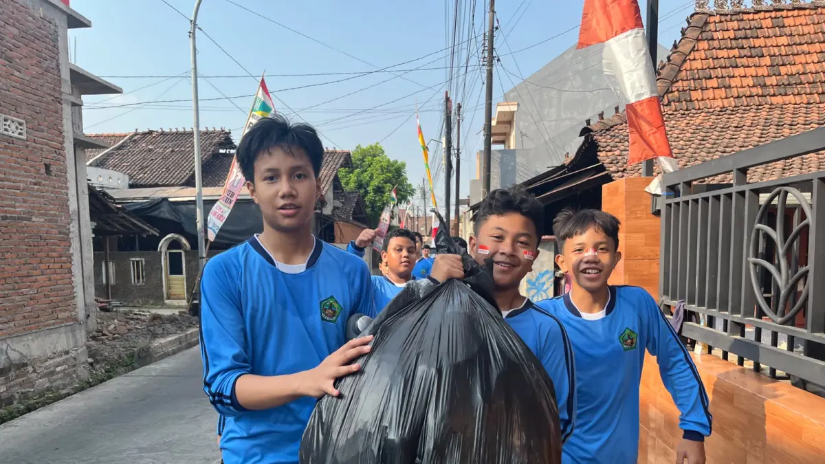 Peserta jalan sehat memungut sampah di sepanjang rute kegiatan HUT ke-81 RI di Kecamatan Kaliwungu, Kudus, Kamis (20/8/2026).
