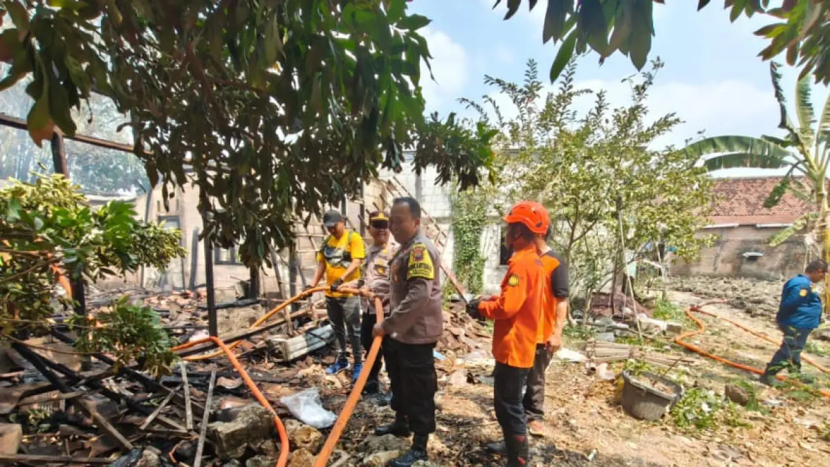 PADAMKAN API – Anggota Polsek Purwodadi melakukan pemadaman api di rumah warga Kelurahan Kalongan, Kecamatan Purwodadi 