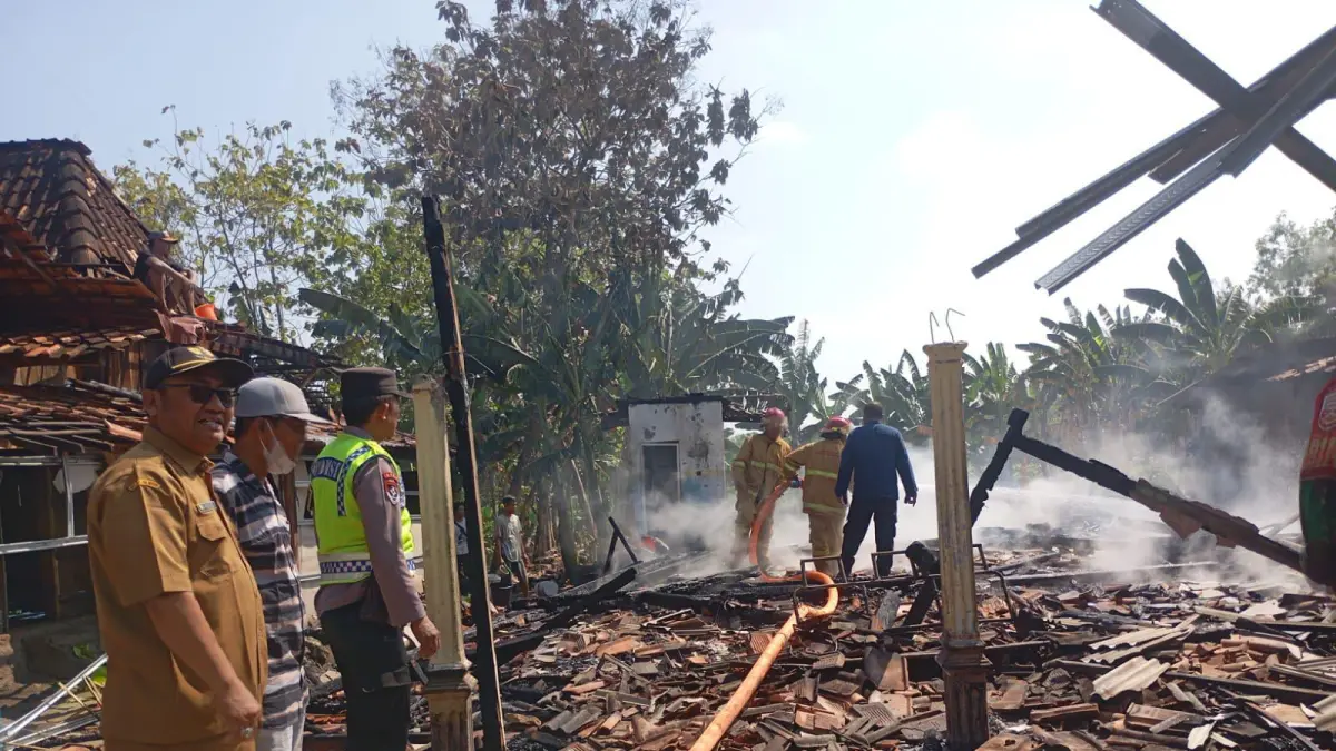 PADAMKAN API – Anggota pemadam kebakaran bersama warga Desa Karangrayung, Kecamatan Karangrayung memadamkan api dari rumah warga setempat. 
