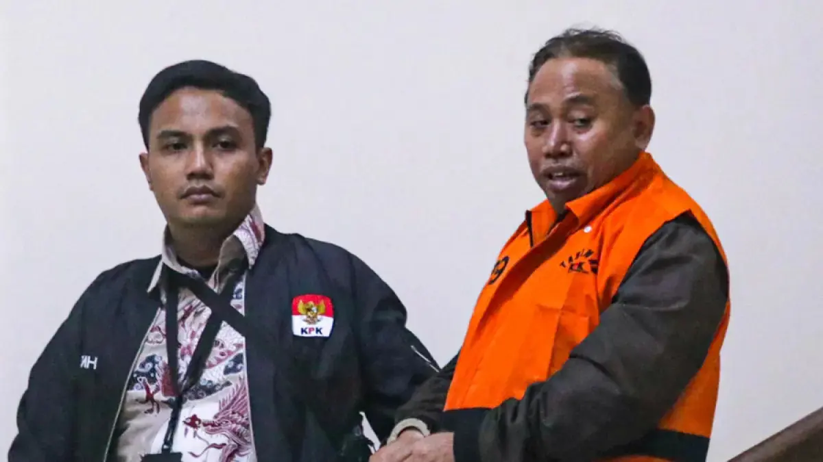 Rektor Universitas Jenderal Soedirman (Unsoed) Akhmad Sodiq berjalan menuju mobil tahanan seusai menjalani pemeriksaan di Gedung Merah Putih KPK, Jakarta, Sabtu (22/8/2026) dini hari. (Salman Toyibi/Jawa Pos)