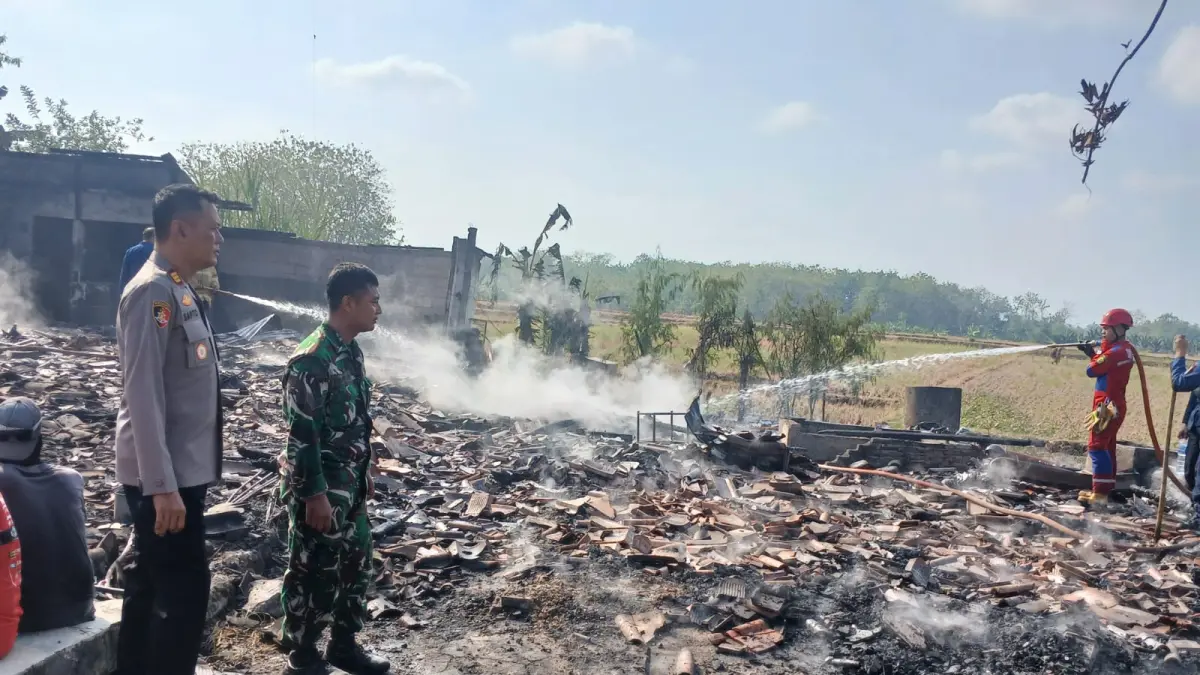 PADAMKAN API – Anggota Damkar bersama Polsek Wirosari dibantu warga melakukan pemadaman api yang menghanguskan tiga rumah warga Desa Sambirejo, Kecamatan Wirosari. 
