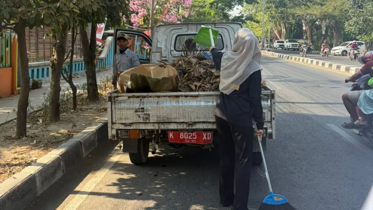 KERJA EKSTRA: Para pegawai DLH Rembang menyapu jalan setelah karyawan outsourcing tak diperpanjang lagi kontraknya.