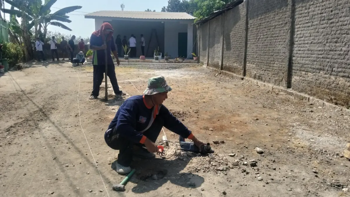 DIBONGKAR: Pihak warga Desa Kutoharjo, Pati Sarwi mencoba membongkar area makam desa setempat kemarin. (ANDRE FAIDHIL FALAH/RADAR KUDUS)