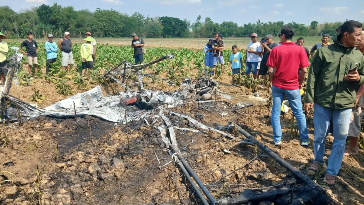 BAHAYA: Warga saat mengerumuni pesawat jatuh di areal persawahan wilayah Kecamatan Ngawen, Minggu (06/09). (EKO SANTOSO/RADAR KUDUS)