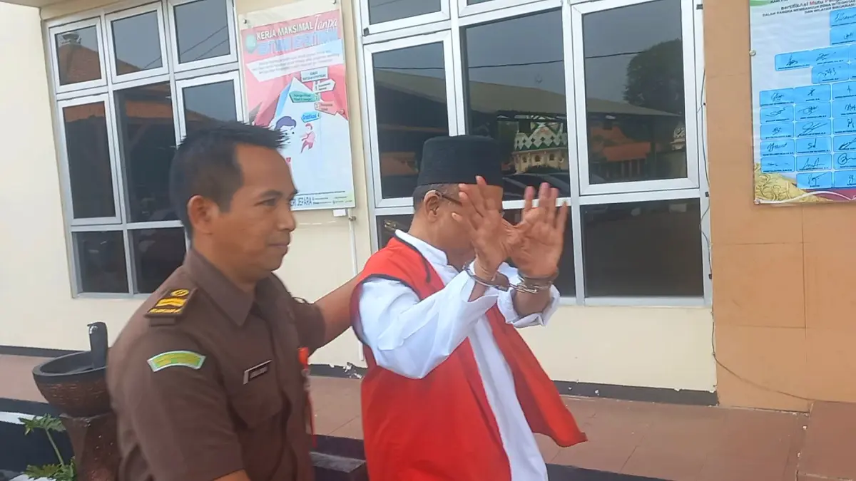 SIDANG LANJUTAN: Terdakwa KS, Abi Jamroh (60) mencoba menutupi muka saat memasuki Ruang Sidang Cakra di PN Jepara pada Kamis (10/9). (FIKRI THOHARUDIN/RADAR KUDUS)