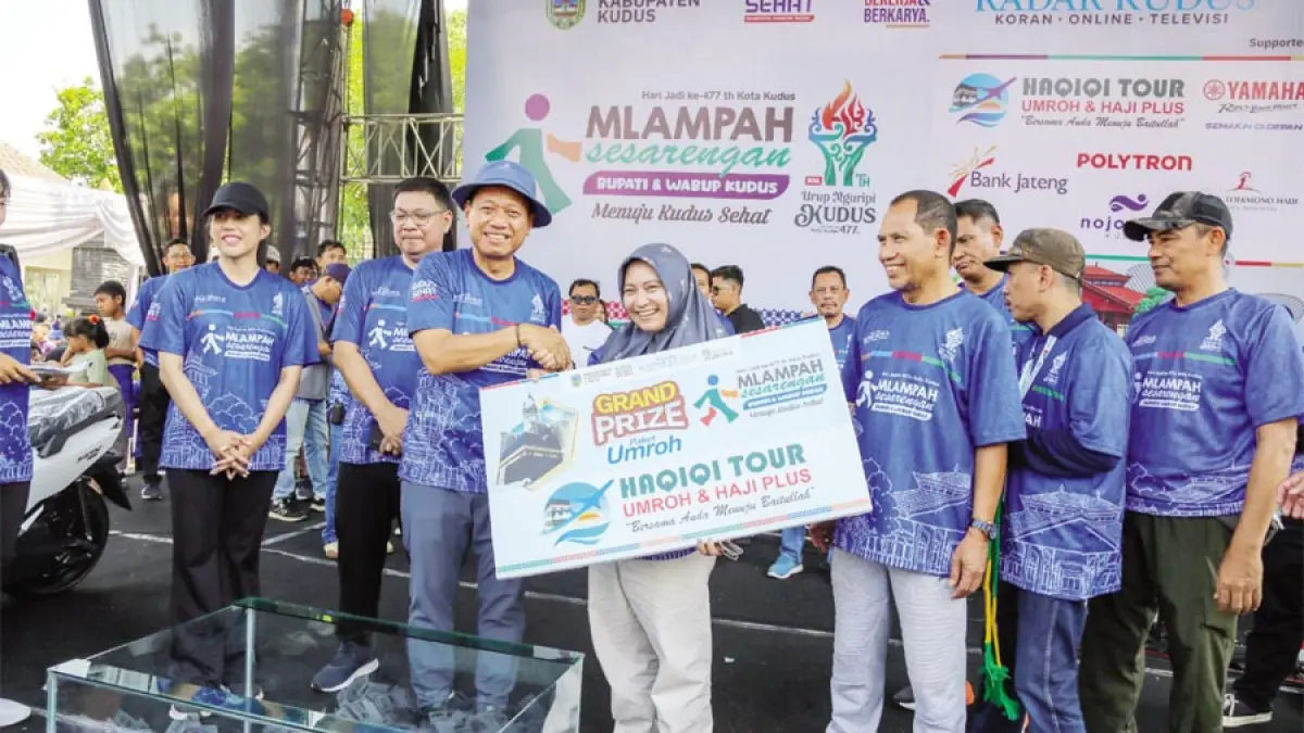 BERKAH: Bupati Kudus Sam’ani Intakoris bersama Wakil Bupati Kudus Bellinda Birton (kiri) menyerahkan&nbsp;hadiah simbolis pemenang hadiah utama umroh Mlampah Sesarengan Bupati dan Wakil Bupati Kudus didampingi Direktur Jawa Pos Radar Kudus Baehaqi (empat kanan) dan perwakilan dari Haqiqi Tour&nbsp;Kudus serta Kodim 0772/Kudus dan Kepolisan Kudus. (GALIH ERLAMBANG/RADAR KUDUS)