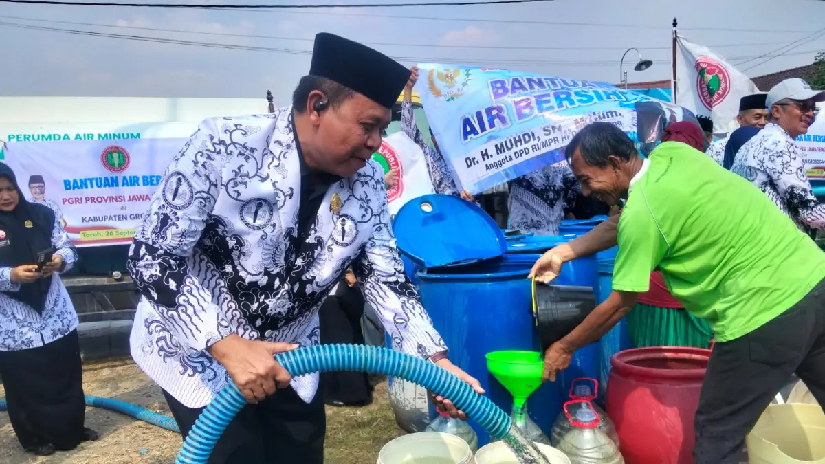 PEDULI: Ketua PGRI Kabupaten Grobogan Purnyomo saat menyalurkan air bersih.