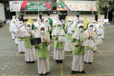 PANDEMI TETAP BERPRESTASI: Para siswi peraih juara dalam sembilan lomba tingkat internasional foto dengan piagam dan medali yang diraih didampingi kepala MA NU Banat serta guru pendamping. (M ULIN NUHA/RADAR KUDUS)